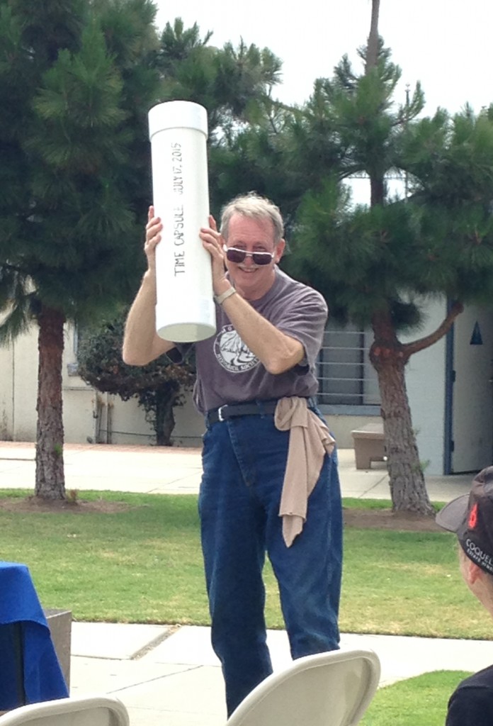 Roger Castle holds the time capsule aloft.