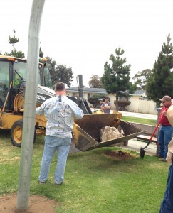 The city crew places a large rock over the time capsule.