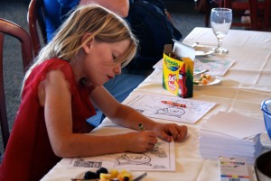 A girl colors a picture of Sammy the Steelhead Trout during the party.