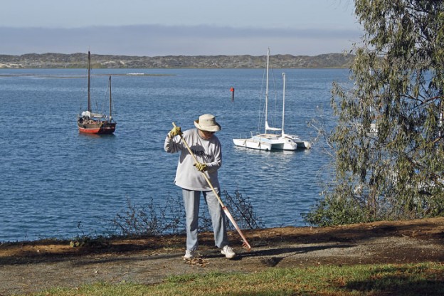 Doreen rakes the path along the water’s edge. Photograph courtesy of Ruth Ann Angus.