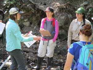 Monitoring Coordinator Karissa explains to volunteers how to collect habitat data such as water depth and creek bottom characteristics.