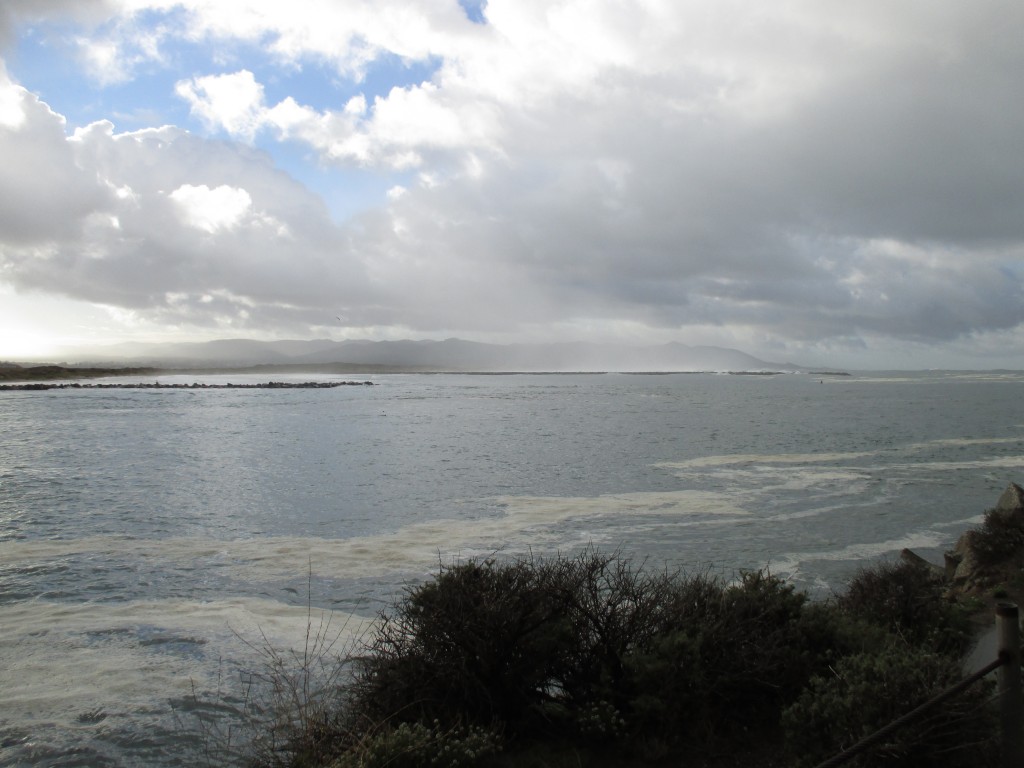 Clouds roll in over the harbor mouth on a stormy morning.