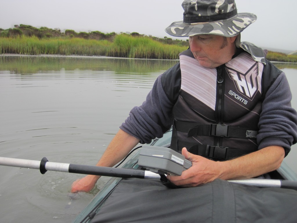 Here a volunteer takes water quality measurements in Sharks Inlet.