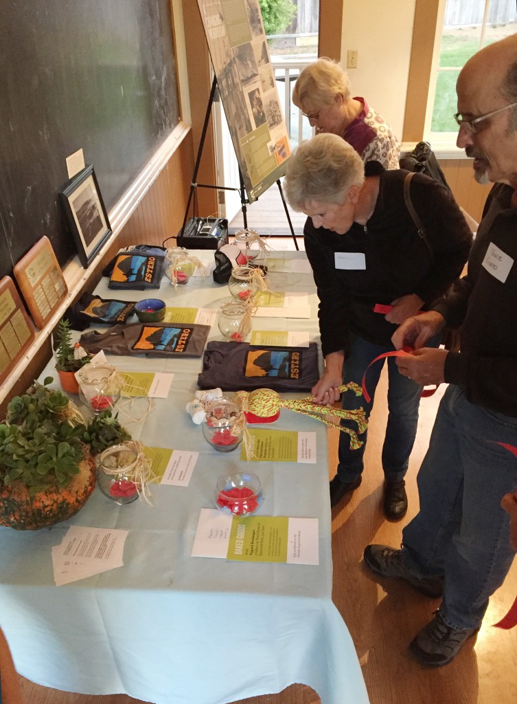 Volunteers peruse the raffle table, filled with gifts from local businesses to recognize the great work they do for our bay.