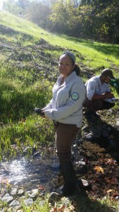 Lauren waits for the equipment to stabilize before recording temperature, dissolved oxygen, and specific conductivity at a site on Pennington Creek. Khaalid looks for fish and makes note of any algae in the water.