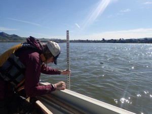 Carolyn uses a stadia rod (a giant ruler) to measure the water depth near a buoy at high tide.
