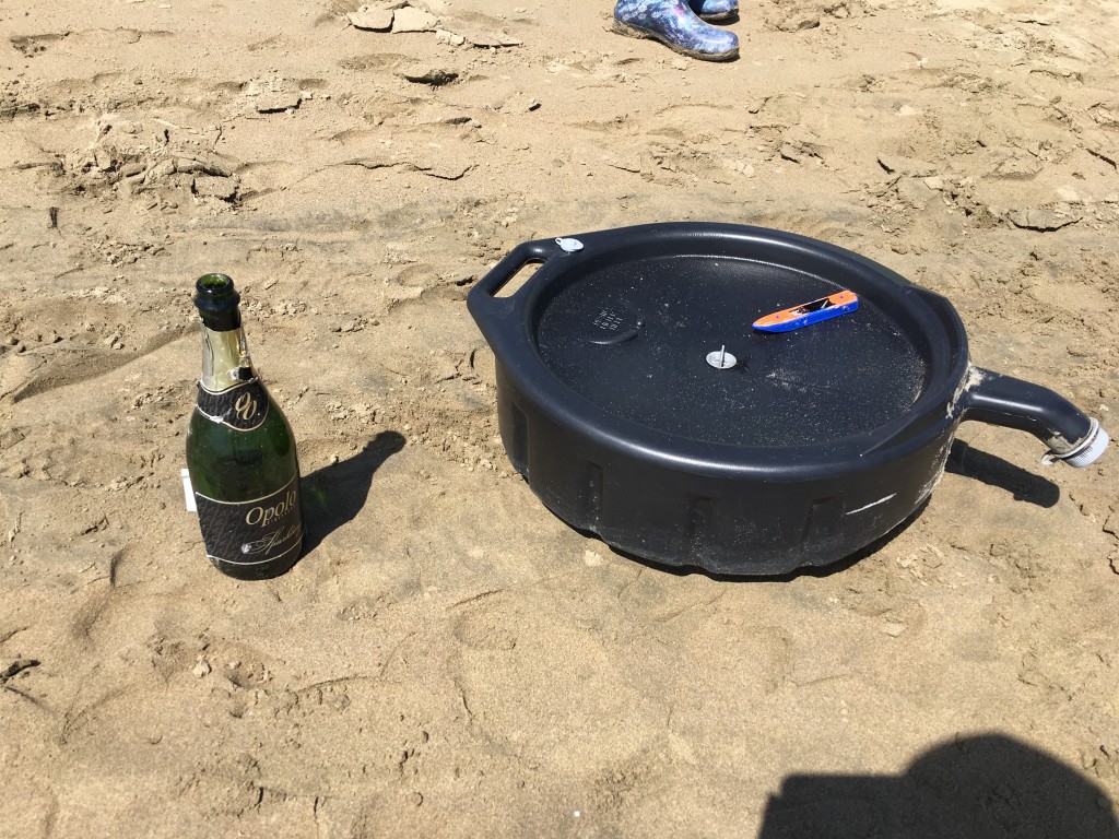 A few of our strange items, including a half-full bottle of champagne, a used oil pan, and a toy boat. 