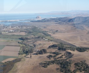 This photograph shows Morro Rock, Morro and Estero Bays, and a portion of the watershed. It was taken from the window of a plane in 1988, seven years before the establishment of the Morro Bay National Estuary Program.
