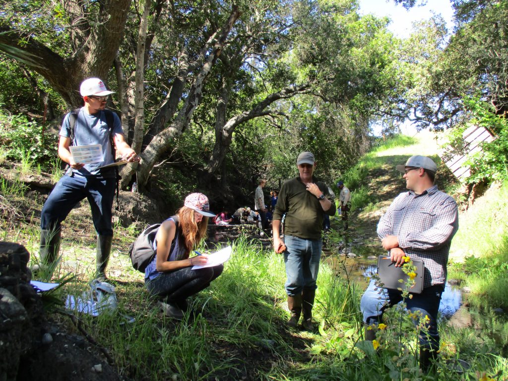 Marc, center, talks with a group of volunteers during a bioassessment survey training. 