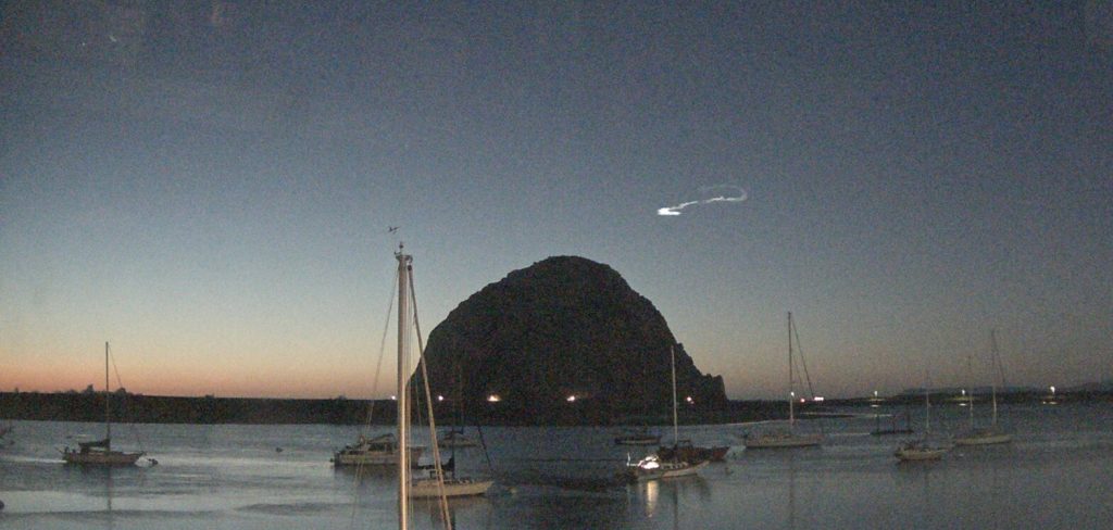 A noctilucent cloud hangs in the sky over Morro Rock