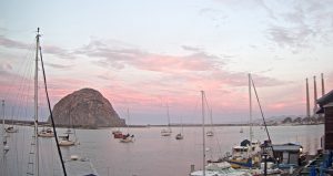 A pink and purple sunrise behind Morro Rock