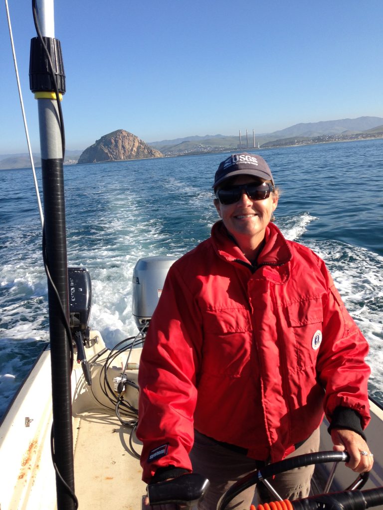 Gena Bentall drives a boat during a sea otter study.