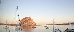 Golden morning light glows behind Morro Rock.