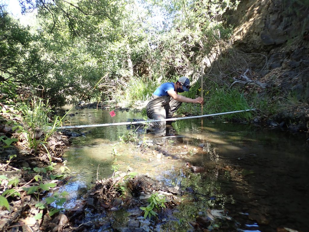 An Estuary Program staff member takes water depth measurements.