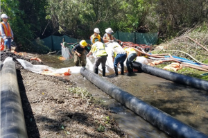 People help dewater a creek.