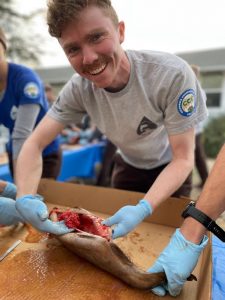 WSP Corpsmember posing with a fish during a dissection.