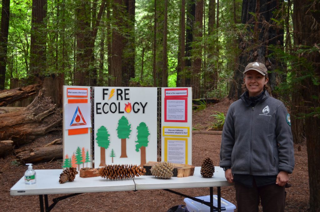 Raine presenting an information for students at an education fair on fire ecology.